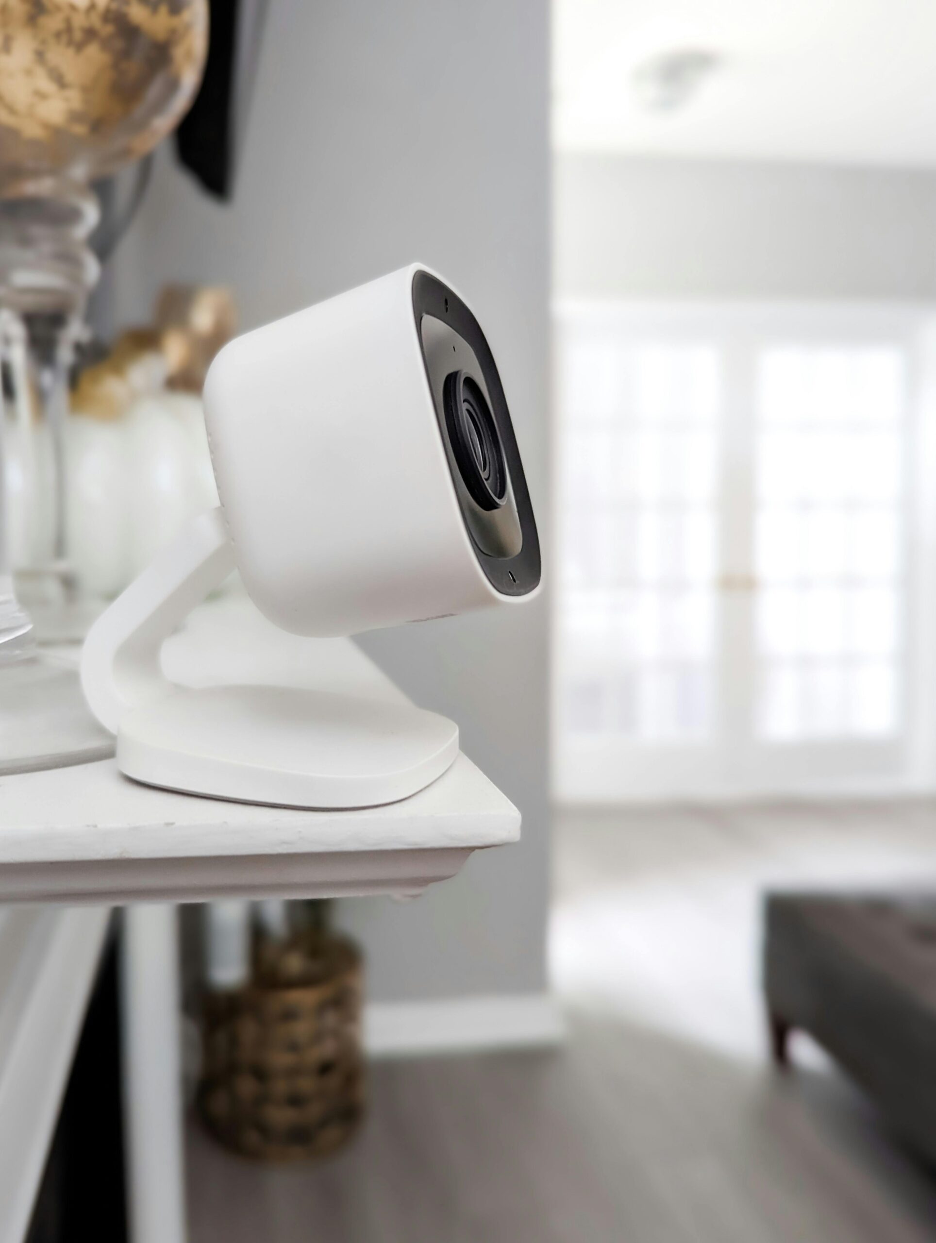Sleek white home security camera positioned indoors, capturing a modern and minimalist interior setup.